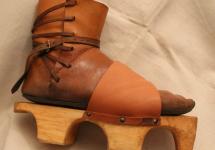Medieval shoes to be laced up with leather straps, with wooden soles